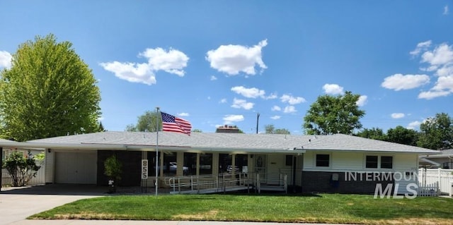 855 N 9th E, Mountain Home, ID 83647 - view of front of house with an attached garage, concrete driveway, a carport, and a chimney