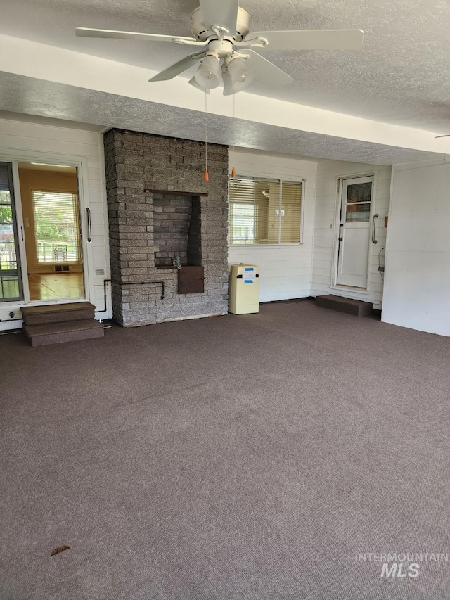 855 N 9th E, Mountain Home, ID 83647 - unfurnished living room featuring carpet floors, a textured ceiling, and ceiling fan