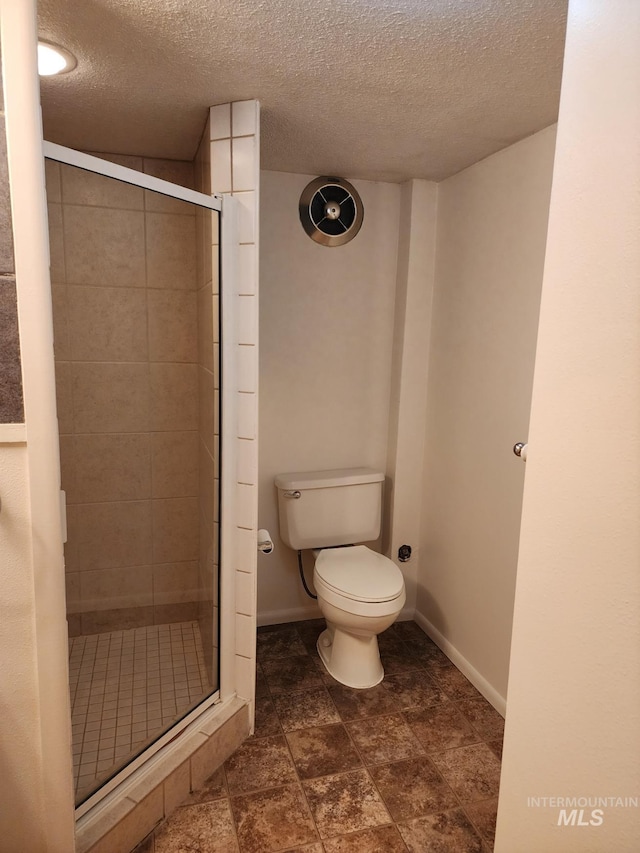 855 N 9th E, Mountain Home, ID 83647 - bathroom with a shower stall, a textured ceiling, toilet, and baseboards