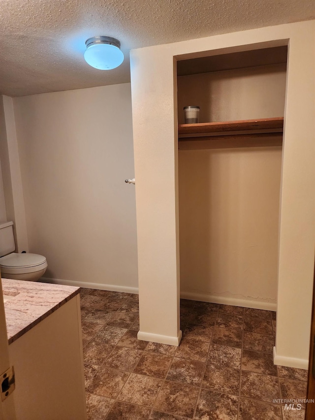 855 N 9th E, Mountain Home, ID 83647 - bathroom with a textured ceiling, vanity, and baseboards