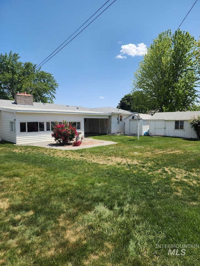855 N 9th E, Mountain Home, ID 83647 - rear view of property featuring a yard and a chimney