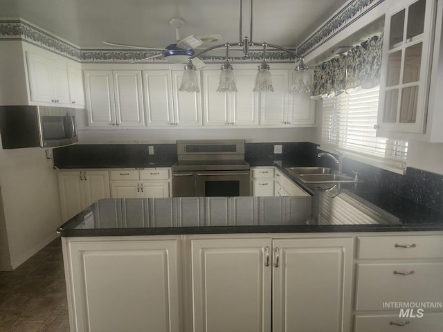 855 N 9th E, Mountain Home, ID 83647 - kitchen featuring appliances with stainless steel finishes, a sink, white cabinets, a peninsula, and glass insert cabinets