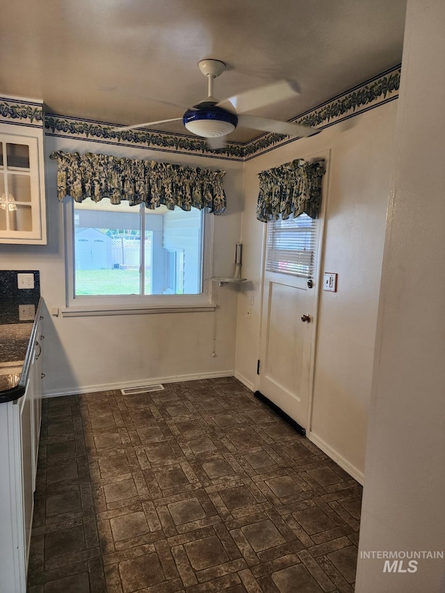 855 N 9th E, Mountain Home, ID 83647 - unfurnished dining area with plenty of natural light, baseboards, and a ceiling fan