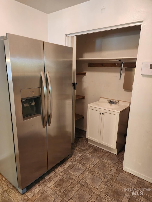 855 N 9th E, Mountain Home, ID 83647 - kitchen with stainless steel fridge, open shelves, a sink, white cabinets, and light countertops