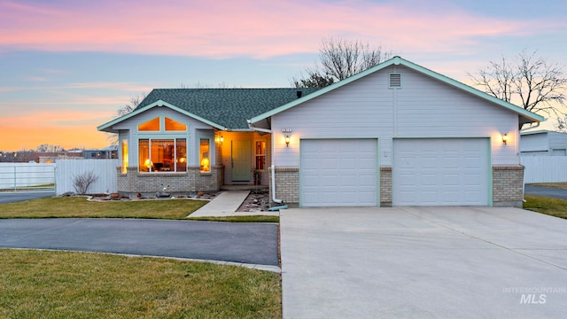 view of front of property with driveway, fence, a yard, a garage, and brick siding