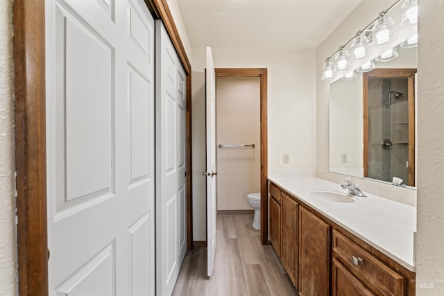 full bathroom with wood finished floors, vanity, and toilet