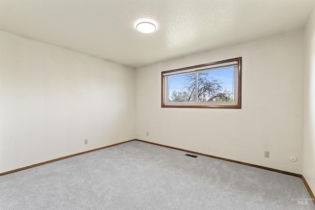 spare room with visible vents, baseboards, and carpet floors