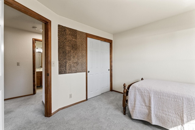 carpeted bedroom featuring baseboards and a closet
