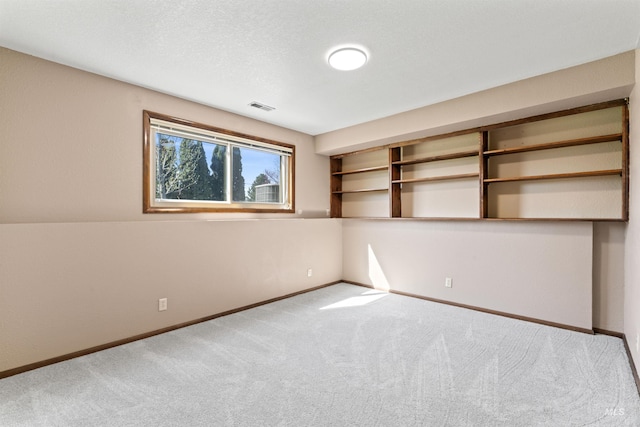 carpeted spare room featuring visible vents and baseboards