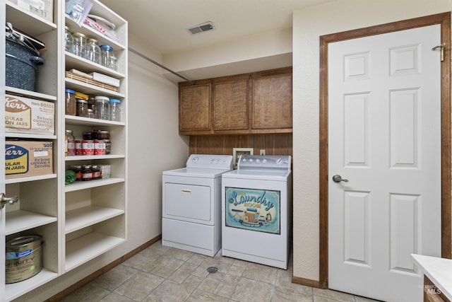 laundry area featuring baseboards, visible vents, washer and dryer, and cabinet space