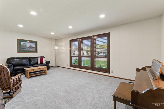 carpeted living area featuring baseboards and recessed lighting