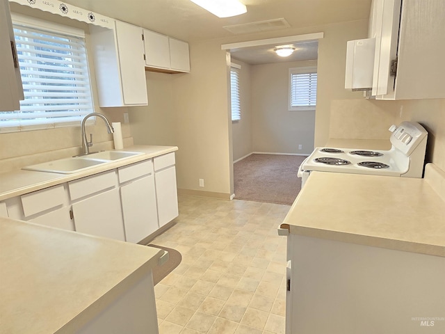 701 Union Ave, Filer, ID 83328 - kitchen featuring white cabinetry, light countertops, baseboards, white range with electric cooktop, and a sink