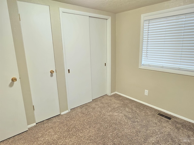 701 Union Ave, Filer, ID 83328 - unfurnished bedroom with baseboards, visible vents, carpet flooring, and a textured ceiling
