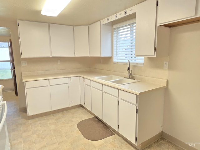 701 Union Ave, Filer, ID 83328 - kitchen featuring white cabinets, light countertops, a sink, and baseboards