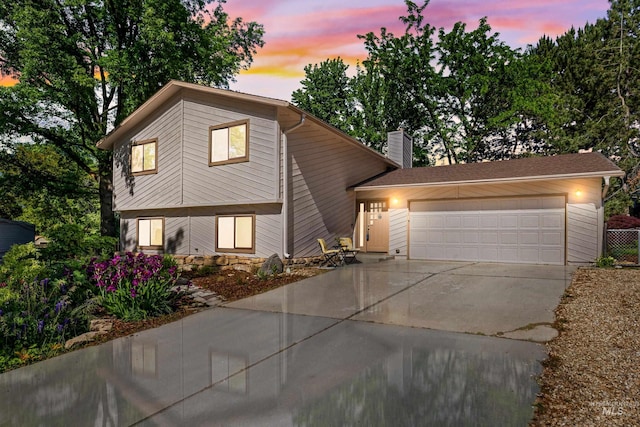 4130 S Ticonderoga Way, Boise, ID 83706 - tri-level home with driveway, a chimney, and an attached garage