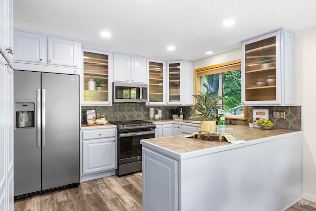 4130 S Ticonderoga Way, Boise, ID 83706 - kitchen with stainless steel appliances, a peninsula, white cabinets, tasteful backsplash, and recessed lighting