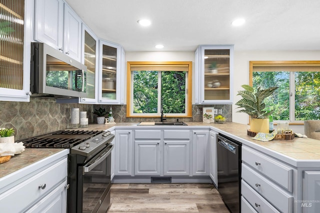 4130 S Ticonderoga Way, Boise, ID 83706 - kitchen featuring stainless steel microwave, range with gas stovetop, black dishwasher, a sink, and tasteful backsplash