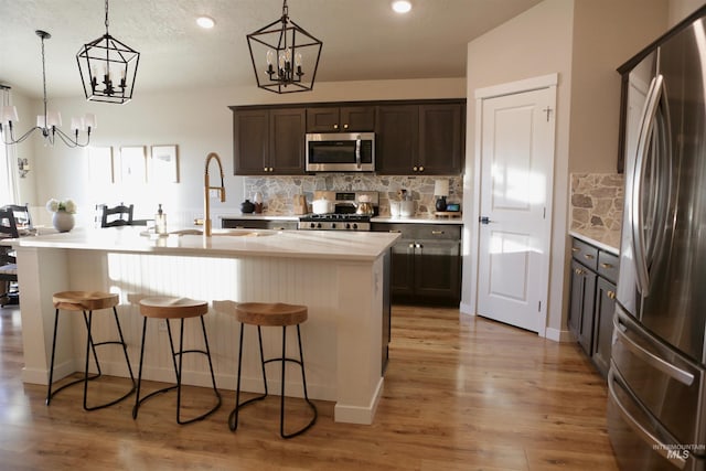 2188 Navigator St, Middleton, ID 83644 - kitchen with appliances with stainless steel finishes, a chandelier, light countertops, a breakfast bar area, and recessed lighting