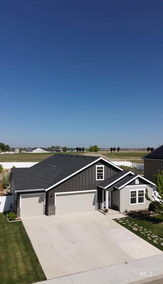 2188 Navigator St, Middleton, ID 83644 - view of front of property featuring board and batten siding, concrete driveway, an attached garage, a water view, and a front yard