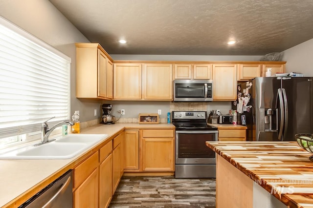 kitchen featuring wooden counters, sink, dark hardwood / wood-style floors, a textured ceiling, and stainless steel appliances