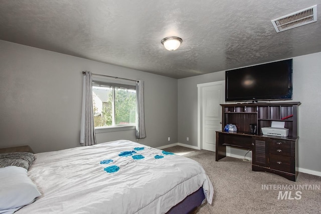 carpeted bedroom featuring a textured ceiling