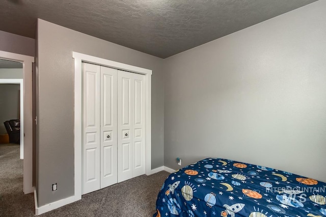 bedroom with a textured ceiling, carpet floors, and a closet