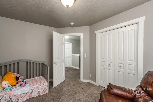 bedroom with carpet, a textured ceiling, and a closet