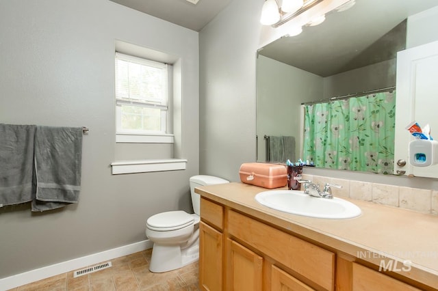 bathroom featuring tile patterned flooring, vanity, and toilet