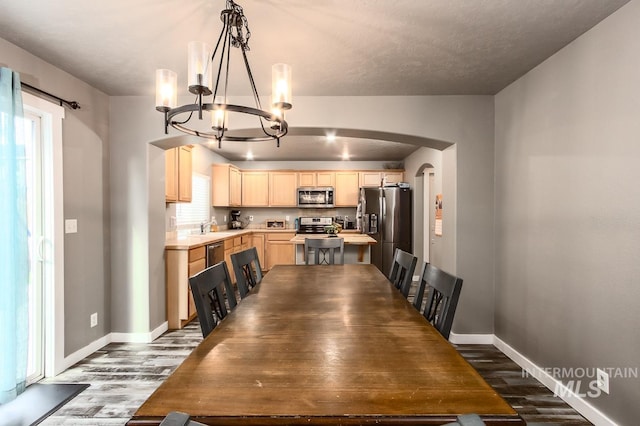 dining area with a chandelier, a textured ceiling, dark hardwood / wood-style floors, and sink