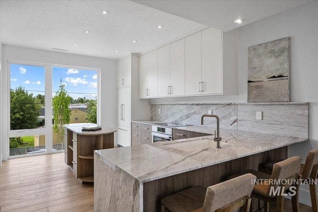 333 E Palapa Ln, Garden City, ID 83714 - kitchen featuring a sink, recessed lighting, light wood-style flooring, tasteful backsplash, and oven