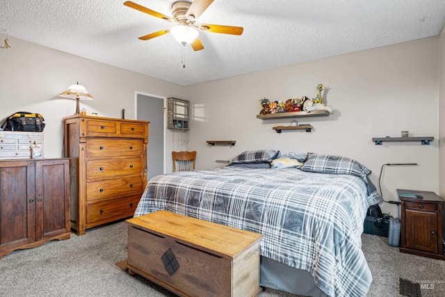 bedroom featuring a textured ceiling, ceiling fan, and light colored carpet