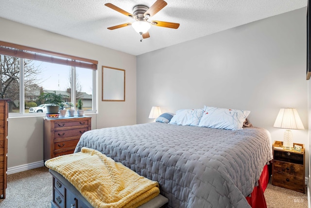 bedroom featuring a textured ceiling, ceiling fan, baseboards, and light colored carpet