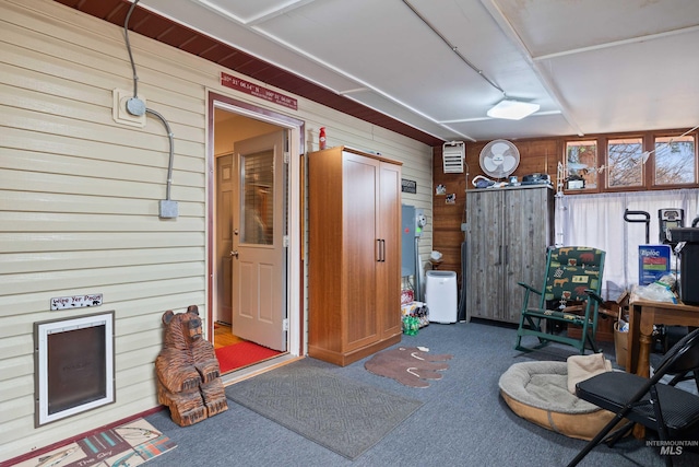 misc room with carpet and wood walls