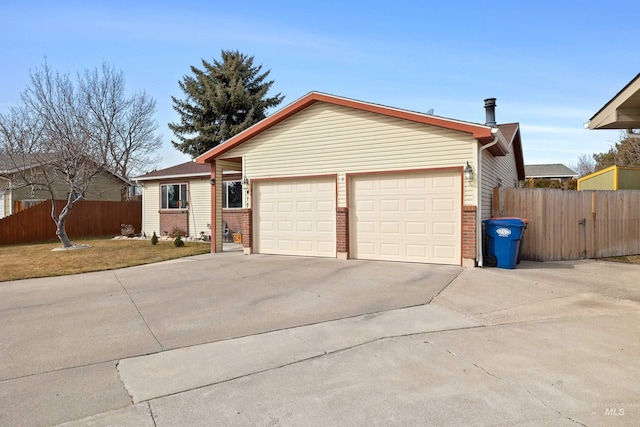 view of front of house with driveway, brick siding, an attached garage, and fence