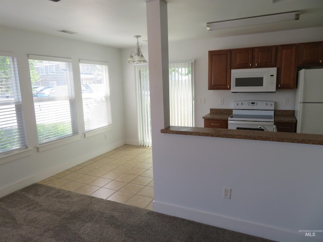 11026 W Garverdale Ln, Boise, ID 83713 - kitchen featuring white appliances, a chandelier, dark countertops, light tile patterned floors, and light carpet