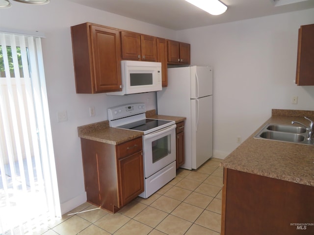 11026 W Garverdale Ln, Boise, ID 83713 - kitchen with white appliances, a sink, light tile patterned flooring, brown cabinetry, and light countertops