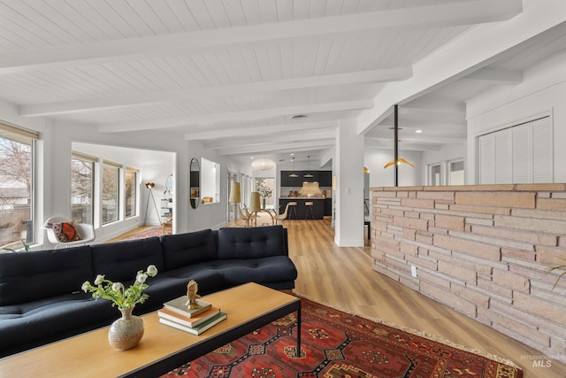 living room with beam ceiling and wood finished floors