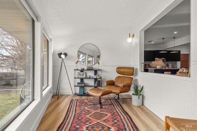sitting room featuring wood finished floors and crown molding
