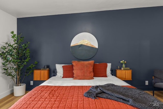 bedroom featuring wood finished floors and baseboards