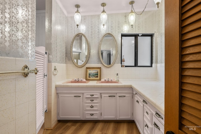 bathroom with crown molding, vanity, tile walls, and wood finished floors