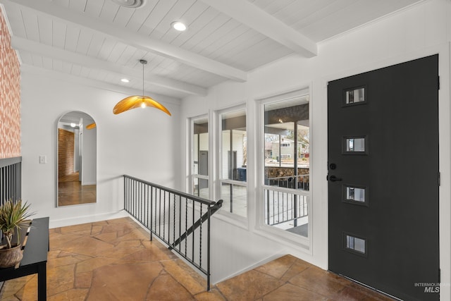 interior space with wood ceiling, beamed ceiling, stone tile flooring, arched walkways, and recessed lighting