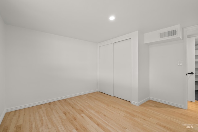 unfurnished bedroom with baseboards, visible vents, and wood finished floors