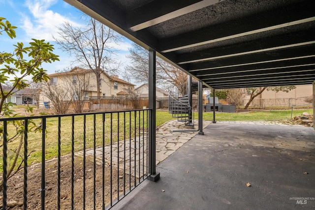view of patio / terrace with fence private yard, a carport, a residential view, and stairs