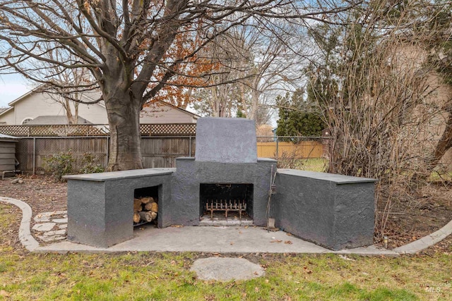view of patio / terrace featuring fence and an outdoor fireplace
