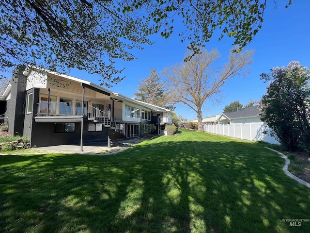 view of yard with fence, a patio area, and stairs