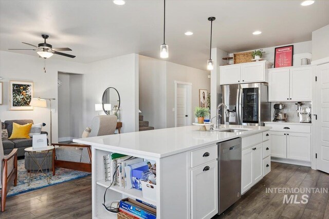 kitchen featuring a center island with sink, dark hardwood / wood-style flooring, ceiling fan, and stainless steel appliances