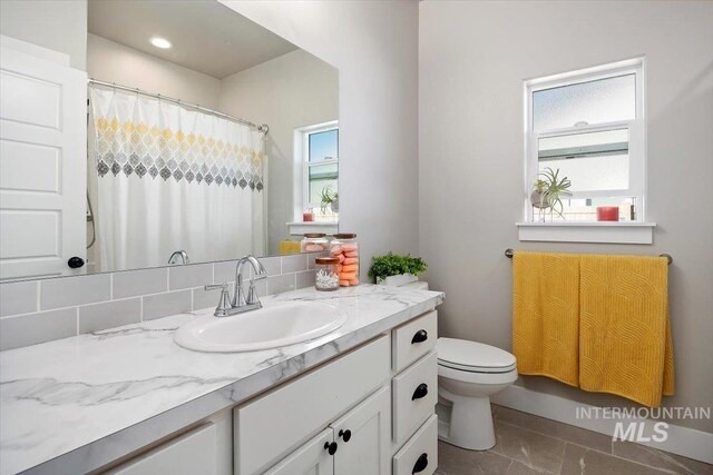 bathroom with backsplash, tile patterned flooring, vanity, and toilet