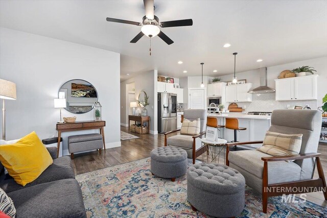 living room featuring dark wood-type flooring and ceiling fan