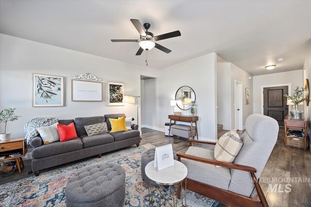 living room featuring ceiling fan and dark hardwood / wood-style flooring