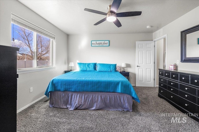 carpeted bedroom featuring ceiling fan and a textured ceiling